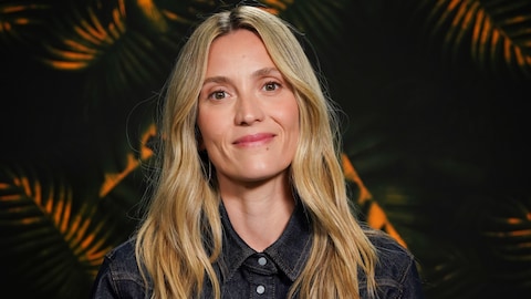 La production est encore jeune / Karine Dufour L'actrice sourit à la caméra devant un décor tropical.