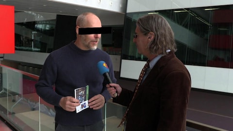Fabien Cloutier a les yeux masqués alors qu'il est en entrevue avec Jean-René Dufort pour l'émission Infoman.