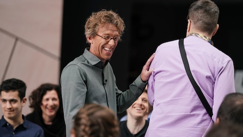 Fred Pellerin met sa main sur l'épaule d'une personne devant lui.