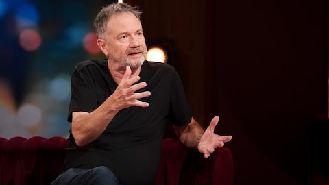François Pérusse parle en agitant les mains.