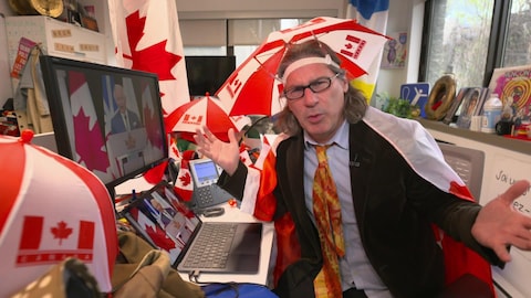 Zone 3 Jean-René Dufort dans un bureau avec des dizaines d'objets à l'effigie du drapeau canadien.