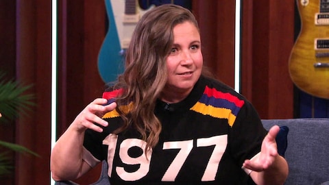 Jessica Barker est assise sur le plateau de l'émission et elle parle en agitant les mains. 