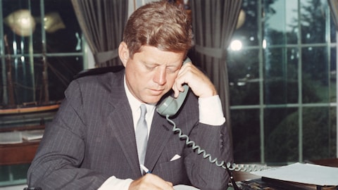 John F. Kennedy parle au téléphone dans le bureau oval.
