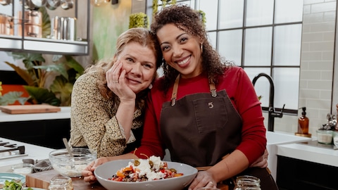 Marina Orsini et Joanna Chery posent avec un plat de salade grecque dans la cuisine.