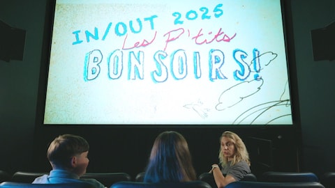 Le trio est assis dans une salle de cinéma.