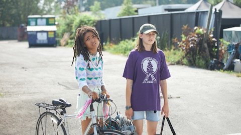 Les deux filles dans la rue, une tant un vélo.