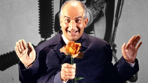 Louis de Funès tient une rose avec son troisième bras.