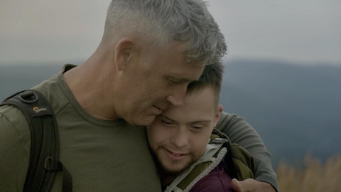 Un homme qui tient son fils dans ses bras.