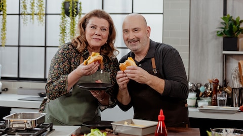 Marina Orsini et Marc Maulà tiennent des sandwichs dans la cuisine.