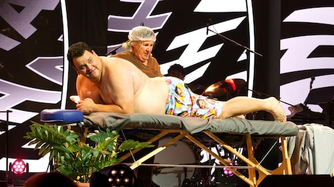 L'homme est allongé sur une table de massage et la femme le regarde. 
