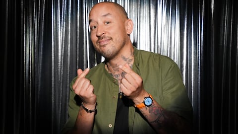 Nicolas Pham pose pour la photographe et fait des signes d'argent avec ses doigts.