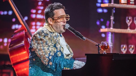 L'homme déguisé en Elton John au piano