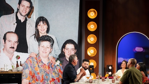 Les cinq personnes sont assises autour d'une table et discutent.