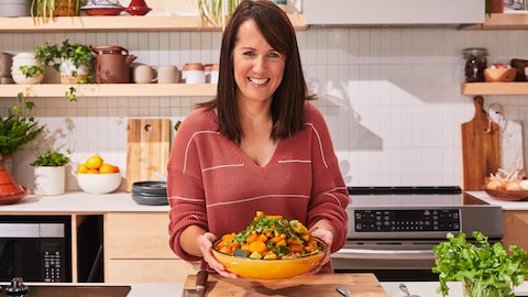Dans sa cuisine, Geneviève O'Gleman tient un plat de couscous.