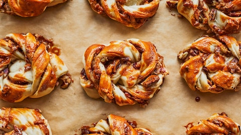 Neuf brioches sur un papier sulfurisé.