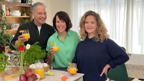 Bernard Fortin, Geneviève O'Gleman et Liliane Blanco-Binette sont autour d'une table et tiennent tous un verre de jus d'orange.