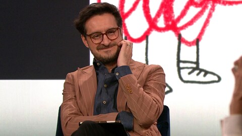 Un homme qui affiche un petit sourire.