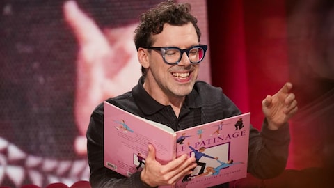 Simon Boulerice tient dans ses mains un livre en racontant une histoire.