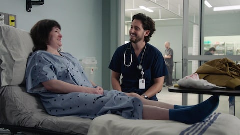 Jacob est face à une patiente sur un lit d'hôpital. Ils rigolent