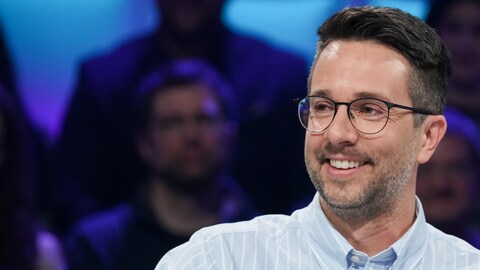 A. Media L'homme est assis en studio.