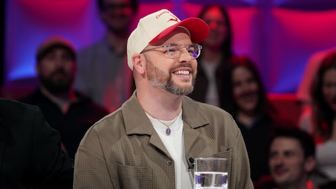 Alexandre Champagne est assis dans le studio.