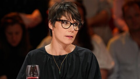 La femme est assise en studio.