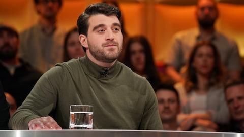 Julien Gendron-Tardif est assis dans le studio.