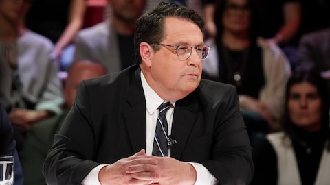 A. Media / Karine Dufour Bernard Drainville est assis dans le studio.
