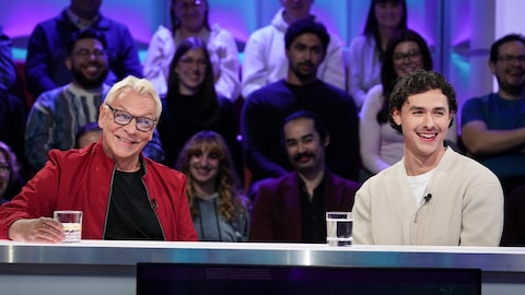 A. Media / Karine Dufour Marc Labrèche et Henri Picard sont assis dans le studio.