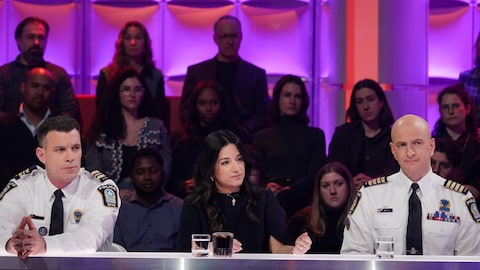 Les trois personnes sont assises dans le studio.