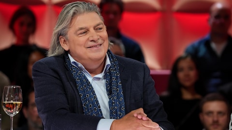 A. Media / Karine Dufour Michel Jean est assis dans le studio.
