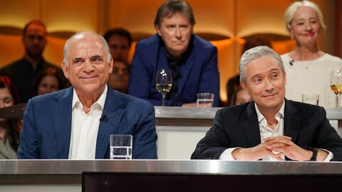 Les deux hommes sont assis en studio.