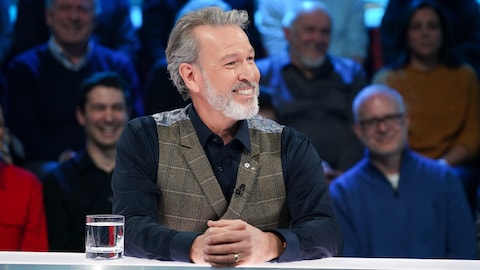 Ricardo Larrivée est assis dans le studio.