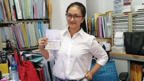 Jeune femme asiatique qui présente fièrement son visa canadien. 
