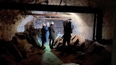 L'équipe d'Infoman dans un tunnel sombre.