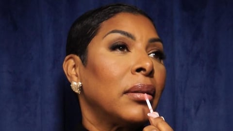 Pamplemousse média Une femme qui met du gloss sur ses lèvres.