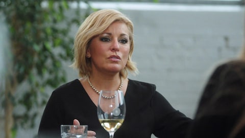 Elle parle à Nathalie Simard, assise à une table de restaurant et devant un verre de vin blanc.