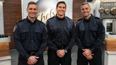 Trois pompiers souriants.