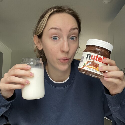 Michelle tient un verre de lait et un pot de Nutella 