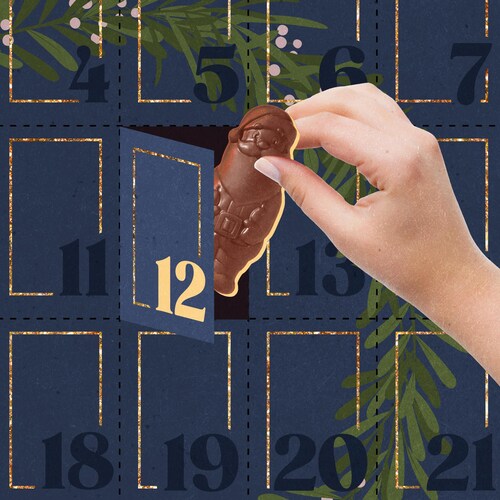 Une main sortant un chocolat en forme de père Noël d'un calendrier de l'avent.