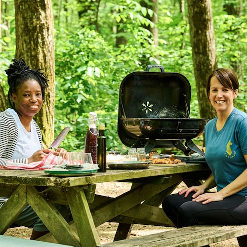 Geneviève et son invitée Rolande Deby cuisinent un choukouya de poulet sur le barbecue.