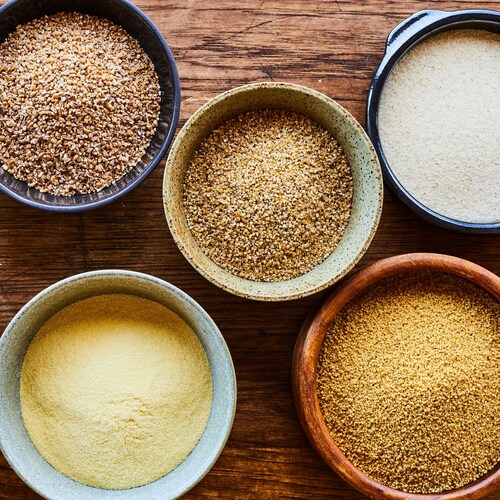 Des bols de grains de blé entier, de blé concassé, de boulgour, de semoule et de couscous.