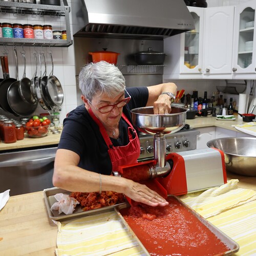 Elena Faita opère un moulin à tomates dans sa cuisine.