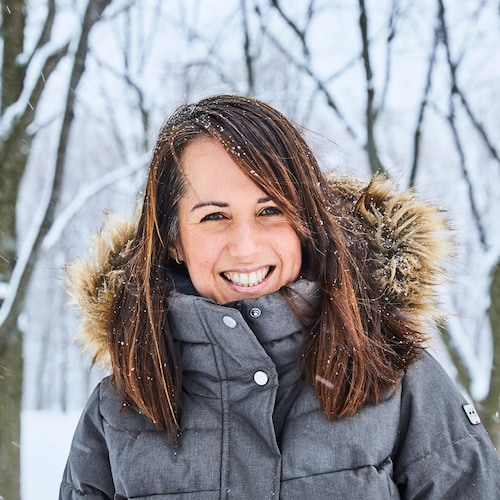 La nutritionniste Geneviève O'Gleman est dehors dans une forêt enneigée et porte un manteau d'hiver gris. 