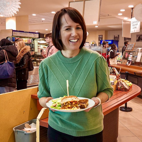 La nutritionniste Geneviève O’Gleman tient une assiette de nourriture et se tient devant la cafétéria de l’école Polytechnique de Montréal.