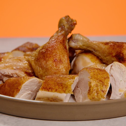 Une assiette avec des ailes, des cuisses, des poitrines et des pilons de poulet cuits. 