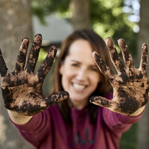 Geneviève O'Gleman montre ses mains pleines de terre à jardin.