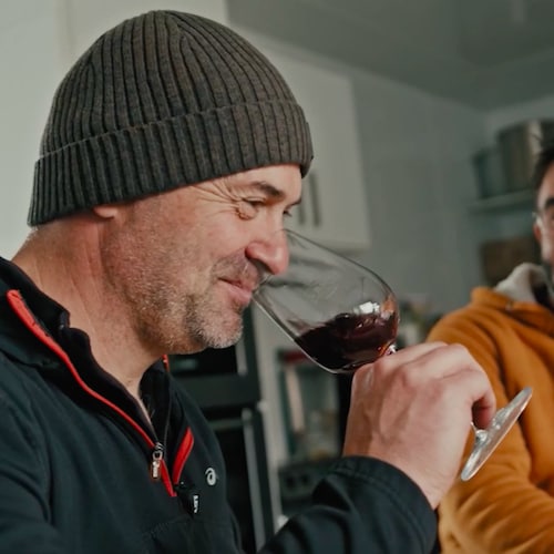 Simon Naud hume un verre de vin à côté de Steve Beauséjour dans un chai.