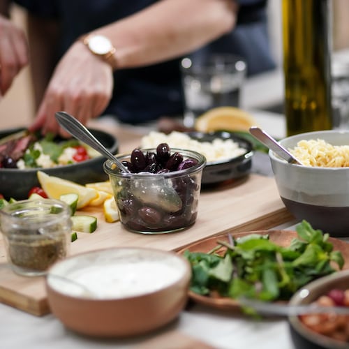 Comptoir rempli de bols d'aliments pour faire un bol-repas : olives, légumineuses, yogourt, fromage...