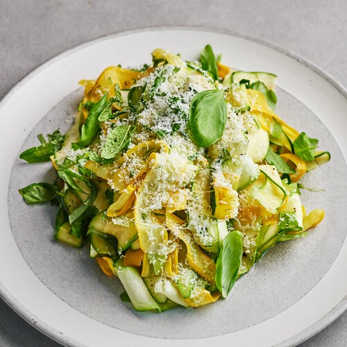 Une salade de courgettes au basilic dans une assiette.